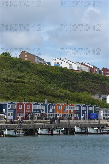 Colourful lobster shacks on the promenade in the lowlands, boats, offshore island of Heligoland,
