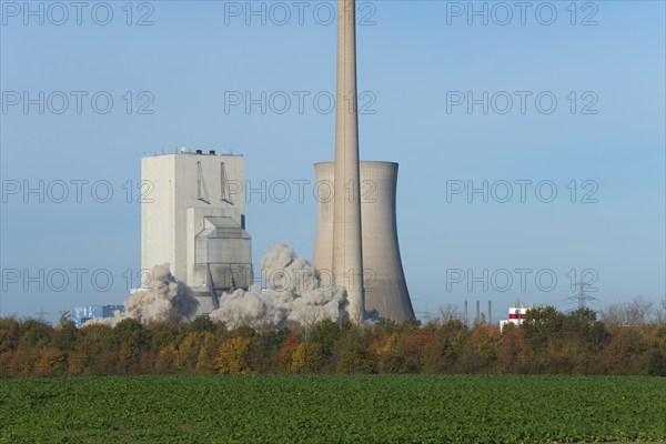 Industrial plant with swirling dust cloud, surrounded by autumnal landscape, blasting of the ash