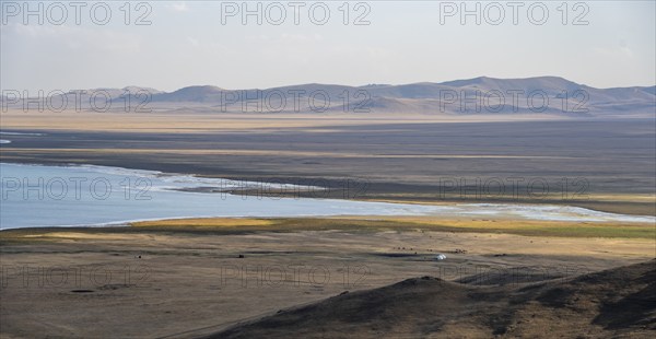 Mountain landscape with Lake Song Kul, view of yurts and horses on the lakeshore, Naryn region,