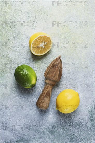 Wooden citrus reamer, manual lemon juicer, made of acacia wood, with citrus fruits on the table,