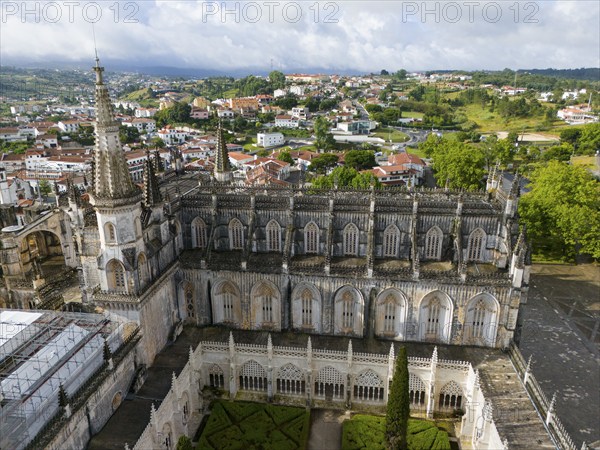 Aerial view of a Gothic cathedral with a magnificent tower and windows, an inner courtyard is