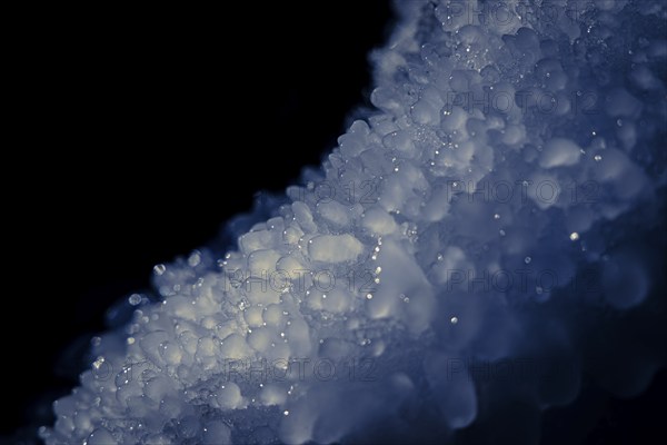 Frozen ice crystals in close-up with blue tint