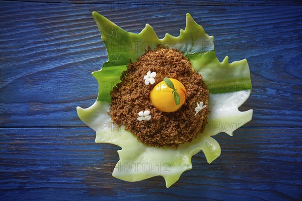 Modern cuisine ice cream with orange spherification and crispy caramelized cookie