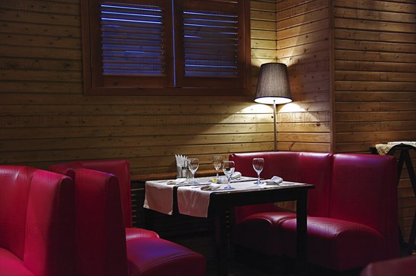 A cozy corner in a cafe, a table with a floor lamp in the twilight