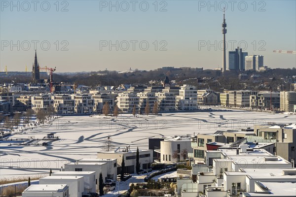 View of the snow-covered and frozen Phoenix Lake and the Florian television tower in Dortmund,