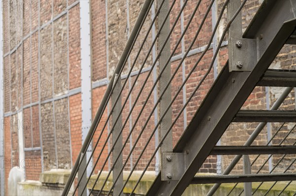 Close up of metal fire escape staircase on old brick wall building