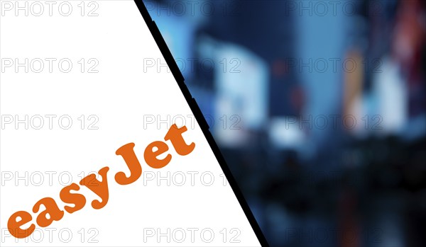 EasyJet logo is displayed on smartphone. EasyJet plc is a British multinational low cost airline