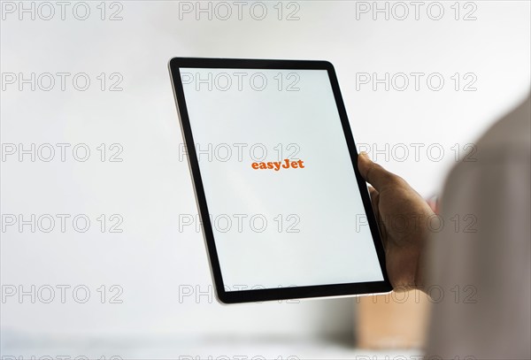 EasyJet logo is displayed on iPad. EasyJet plc is a British multinational low cost airline group.