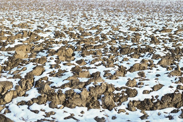Melting snow on plowed soil. Spring view of plowed field
