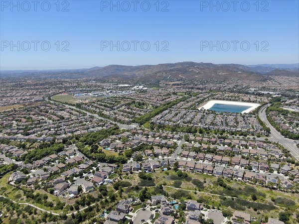 Aerial view of water recycling reservoir surrounded by suburban neighborhood in San Diego County,