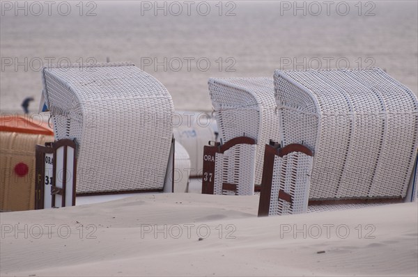 Empty beach chairs stand in a row overlooking the calm sea, Borkum, North Sea, GERMANY