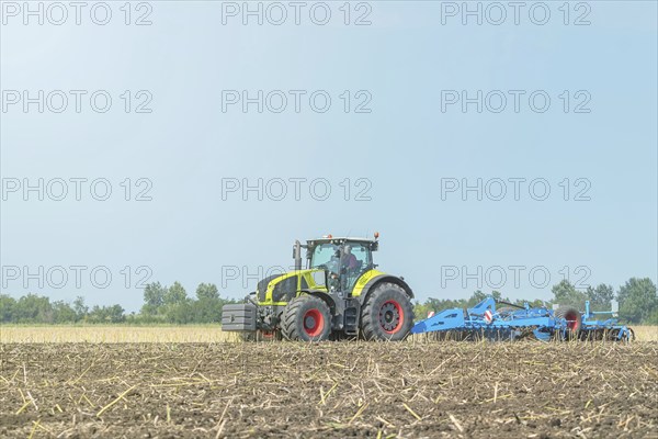 Farmer in tractor preparing land seedbed cultivator. Agriculture tractor landscape