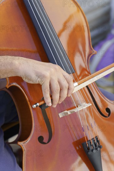 Close-up of unrecognizable man's hands playing the cello