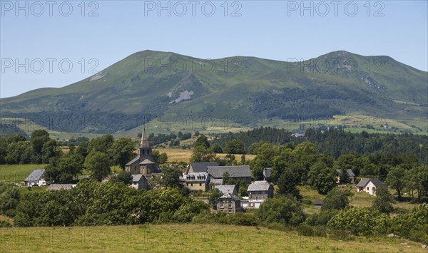 Scenic view of Saint Victor la Riviere village in Auvergne with Mont Dore mountains in the