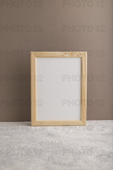 White wooden frame mockup on beige paper background. Blank, vertical orientation, still life, copy
