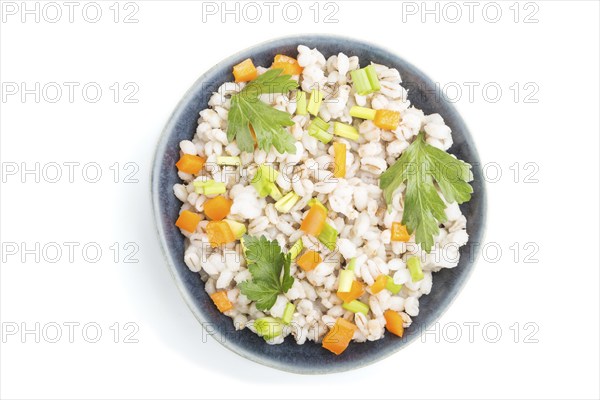 Pearl barley porridge with vegetables in blue ceramic bowl isolated on white background. Top view,