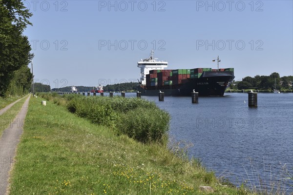 Container ship and cargo ships in a ship siding in the Kiel Canal, Kiel Canal, Schleswig-Holstein,