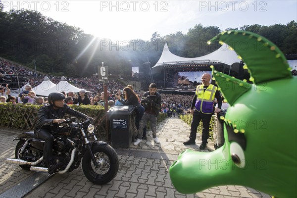 Peter Maffay rides past Tabaluga on his Harley Davidson in front of his concert on We Love Rock 'n'