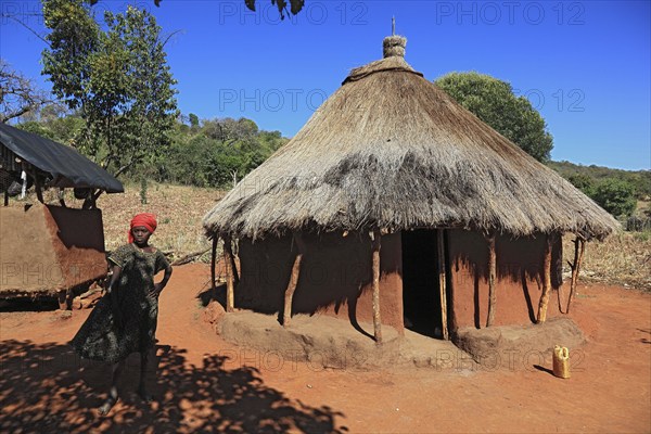South Ethiopia, Benna people, house, hut, woman in front of her round hut in a Benna village,