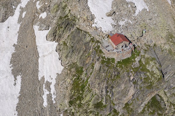 Aerial view of mountain hut Cabane de l'A Neuve, located on a steep rock formation, near La Fouly,