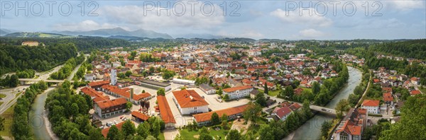 View of a town along a river with red roofs and green surroundings, Traunstein