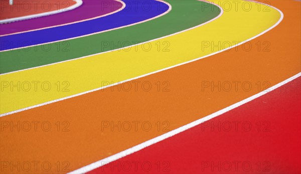 Symbolic image of queer in sport: Running track of an athletics facility in rainbow colours