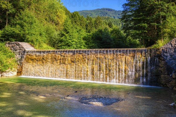 A small waterfall in a wooded area in sunny weather, Bad Feilnbach, Jenbach