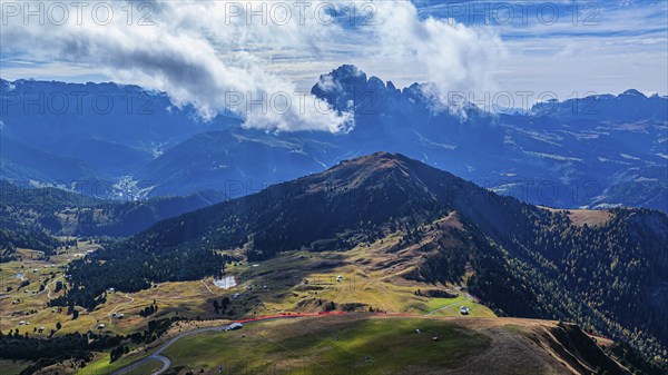 Summit of the Picberg, in the background the peaks of the Sassolungo group, shrouded in fog, drone
