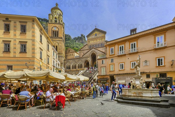 Street café and fountain on the cathedral square with cathedral in the historic centre, Amalfi,