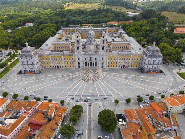 Historical palace captured in impressive symmetry as an aerial view, surrounded by green