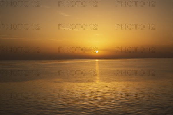 Setting golden sun over Adriatic sea taken from the top deck of a cruise ship in late summer, near