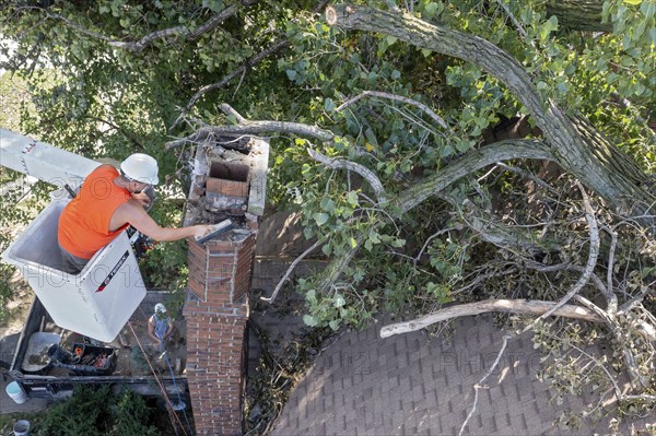Detroit, Michigan, A worker dismantles a brick chimney after a storm with 70mph wind gusts blew