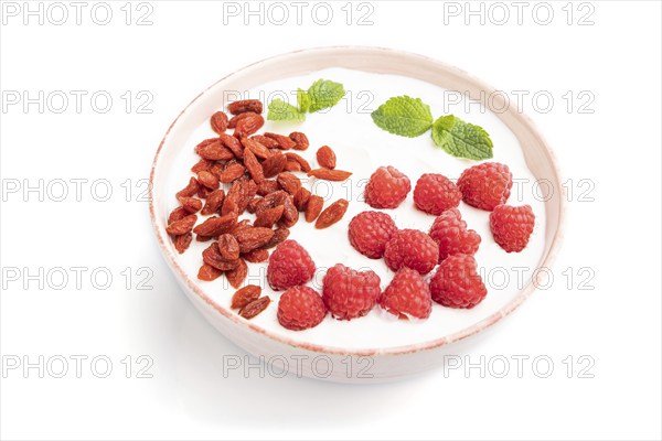 Yogurt with raspberry and goji berries in ceramic bowl isolated on white background. Side view,