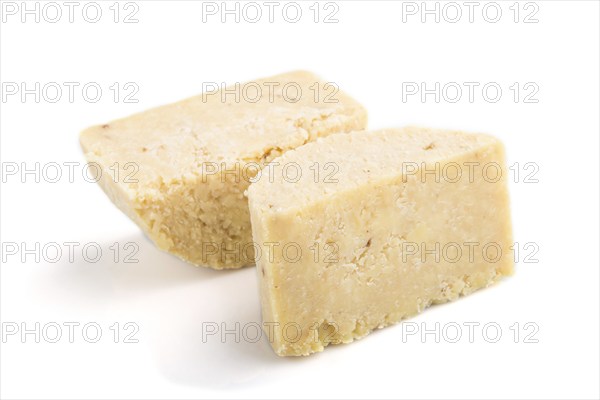 Piece of cheddar cheese isolated on white background. Side view, close up