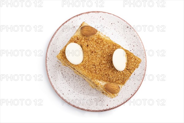Honey cake with milk cream, caramel, almonds isolated on a white background. Top view, flat lay,