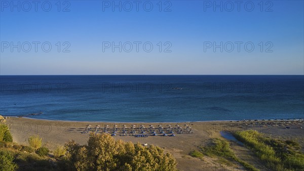 Beach, wetland, umbrellas, sun loungers, green-blue sea, blue cloudless sky, Frangokastello,