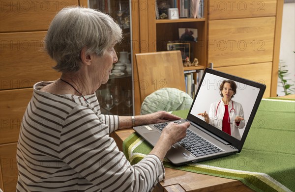 Symbolic image of telemedicine, patient speaking to a doctor in a video conference from home