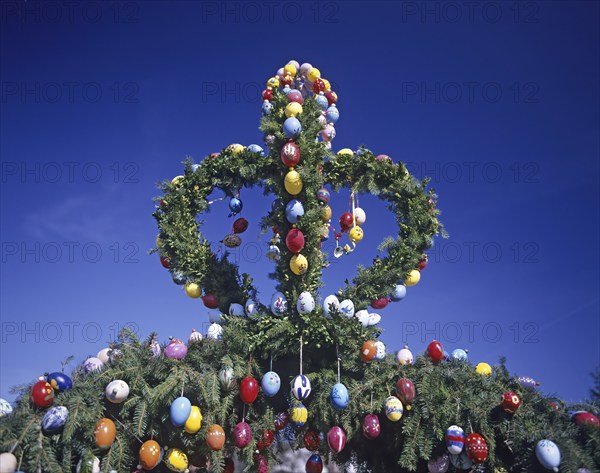 A traditionally decorated Easter tree with colourful Easter eggs under a clear blue sky, Franconian