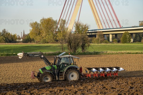 Farmer ploughing a field, tractor with plough, near Neuss, Fleher motorway bridge, A46, North