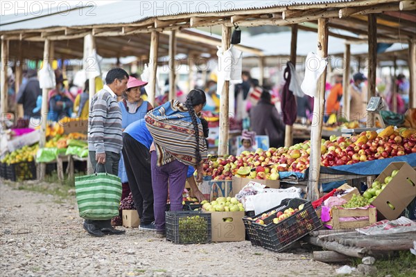 Peruvian family buys fruit at the Indio market in Chinchero, Cusco region, Peru, South America