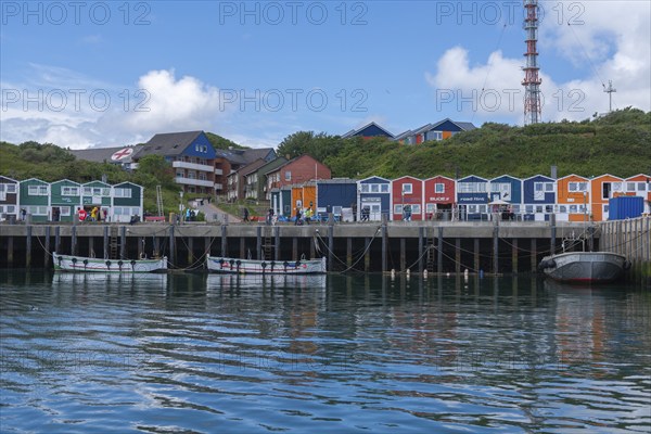 Colourful lobster shacks on the harbour promenade, Börteboote, offshore island Helgoland, blue sky,