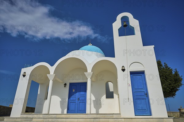White church with blue doors and a bell against a blue sky, Church of Profitis Ilias, above Nikia,