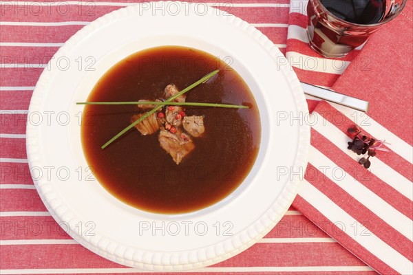 Southern German cuisine, oxtail soup with red pepper in a soup plate, bound soup, meat soup,