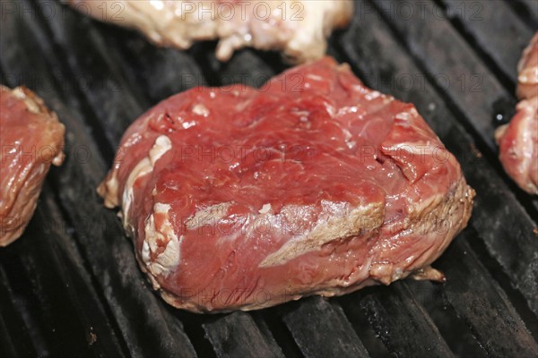 Raw steak on the grill