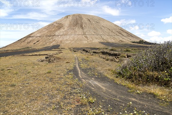 Volcano cone and black volcanic soil farmland, near Tinajo, Lanzarote, Canary Islands, Spain,