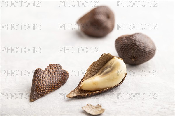 Salak or snake fruit on gray concrete background. Side view, close up, selective focus. Tropical,