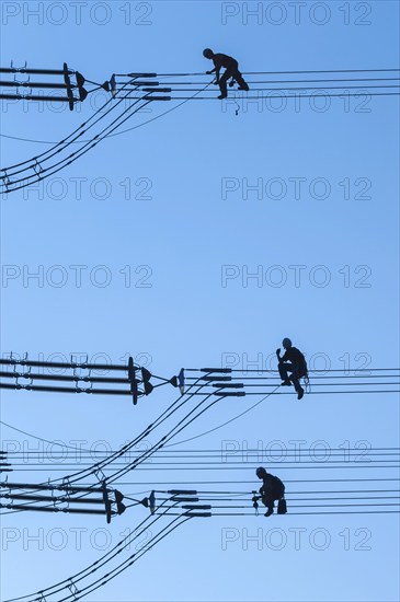 Overhead line fitters working on a high-voltage pylon, overhead lines, energy, worker, high-voltage