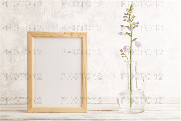 Wooden frame with hosta flowers in glass vase on gray concrete background. side view, copy space,