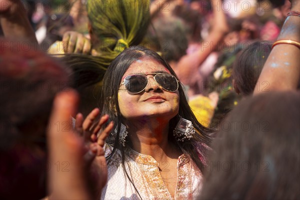 A girl dancing in the beat of music as she celebrate Holi on a street, the Hindu spring festival of