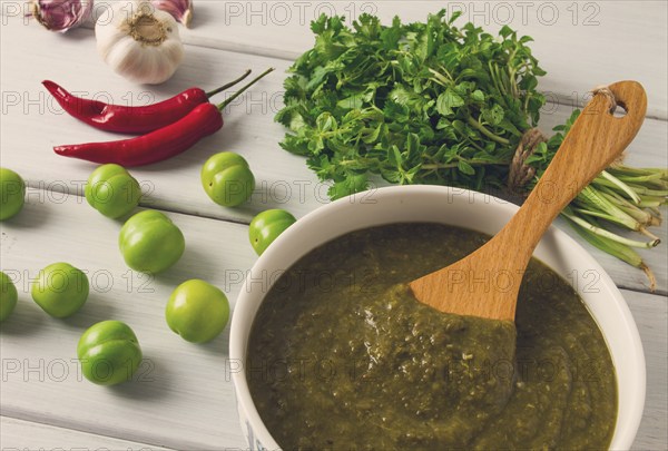 Tkemali sauce, traditional Georgian cuisine, green cherry plum, with ingredients for sauce,